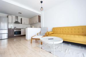 - un salon avec un canapé jaune et une table dans l'établissement Brisa del Delta, à L'Ampolla
