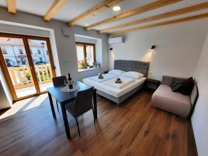 a room with a bed and a table and a couch at Apartments Hlapi with SPA in Kobarid