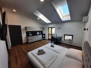 a living room with a large white bed and a kitchen at Apartments Hlapi with SPA in Kobarid