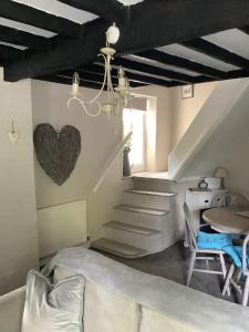 a living room with stairs and a heart on the wall at 1A River Cottage in Baslow