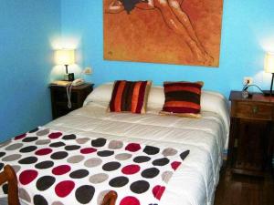a bed in a room with two lamps and a painting at Antia - Casita de piedra en Lariño in Carnota