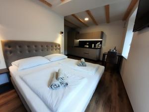 a bedroom with a white bed with towels on it at Apartments Hlapi with SPA in Kobarid