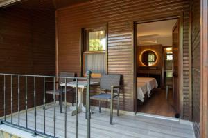 a balcony with a table and chairs and a bedroom at Fener Motel in Şile