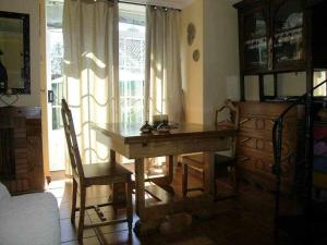 a dining room with a wooden table and chairs at Antia - Casita de piedra en Lariño in Carnota