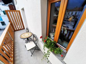 a small balcony with a table and a chair at Apartments Hlapi with SPA in Kobarid