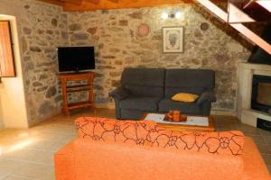 ein Wohnzimmer mit einem Sofa und einem Kamin in der Unterkunft Casa Crina Casa restaurada con finca grande in Outes