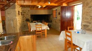 eine Küche und ein Esszimmer mit einem Tisch und Stühlen in der Unterkunft Casa Crina Casa restaurada con finca grande in Outes