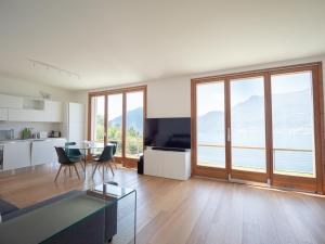 a living room with a table and a large window at Terrazze di Costa - Gardegna 3 in Bellano +26 photos
