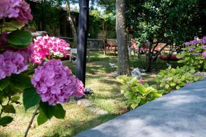 a garden with pink flowers and a bench in the background at Fener Motel in Şile
