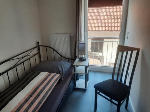 a bedroom with a bed and a chair and a window at Exklusive Wohnoase mit 3 Schlafzimmern MwSt ausweisbar großer Balkon in toller Lage von Melsungen in Melsungen
