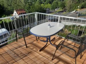 a table and two chairs sitting on a deck at Exklusive Wohnoase mit 3 Schlafzimmern MwSt ausweisbar großer Balkon in toller Lage von Melsungen in Melsungen