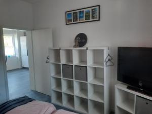 a room with white shelves and a flat screen tv at Exklusive Wohnoase mit 3 Schlafzimmern MwSt ausweisbar großer Balkon in toller Lage von Melsungen in Melsungen