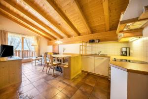 a kitchen with wooden ceilings and a table with chairs at Naturresidenz Theistadl Apt 302 in Pracupola