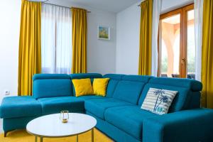 Sofá azul en la sala de estar con mesa en Apartment David, en Kavran