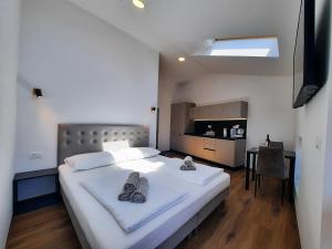 a bedroom with a large white bed with shoes on it at Apartments Hlapi with SPA in Kobarid