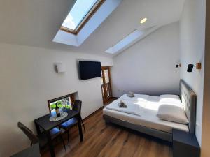 a bedroom with a bed and a table and a skylight at Apartments Hlapi with SPA in Kobarid
