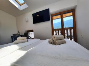 a bedroom with a large bed with two pillows on it at Apartments Hlapi with SPA in Kobarid