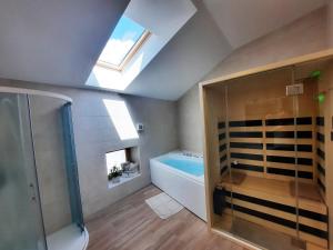 a bathroom with a shower and a bath tub at Apartments Hlapi with SPA in Kobarid
