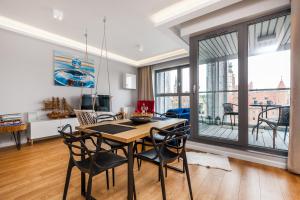 jadalnia ze stołem i krzesłami w obiekcie Uroczy Apartament No1 w ,, SERCU Starego Miasta Wyspa Spichrzów,, w Gdańsku