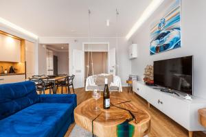 salon z niebieską kanapą i stołem w obiekcie Uroczy Apartament No1 w ,, SERCU Starego Miasta Wyspa Spichrzów,, w Gdańsku