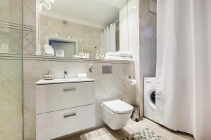 biała łazienka z toaletą i umywalką w obiekcie Uroczy Apartament No1 w ,, SERCU Starego Miasta Wyspa Spichrzów,, w Gdańsku +13 zdjęć