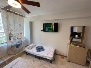 um quarto com uma cama e uma televisão na parede em Jordans rooms 4 em Tessalônica