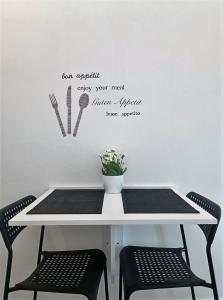una mesa con dos sillas y un cartel en la pared en Studio Apartman Brletić, en Tounj