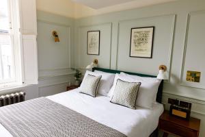 - une chambre avec un grand lit blanc et 2 oreillers dans l'établissement The Bull & Last, à Londres