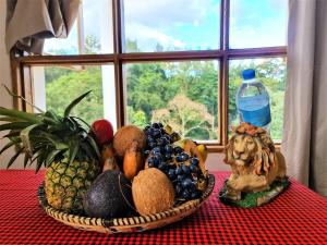 a basket of fruit sitting on a table with a window at Holiday cottage by the river, Arusha in Arusha