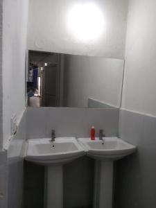 a bathroom with two white sinks and a mirror at Abuzz OxfordCaps, Genome Valley Hyderabad in Hyderabad