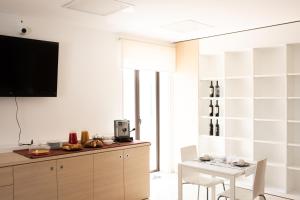 a kitchen with a table and a tv on a wall at G&G Hotel in Grammichele