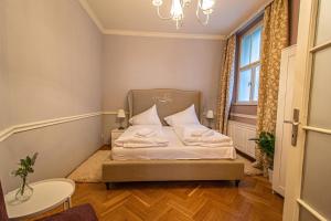 Cette petite chambre comprend un lit avec des draps et des oreillers blancs. dans l'établissement Luxury Central 150m2 Apartment on Wencelas Square with Private Garage, à Prague