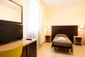 a bedroom with a bed and a flat screen tv at G&G Hotel in Grammichele