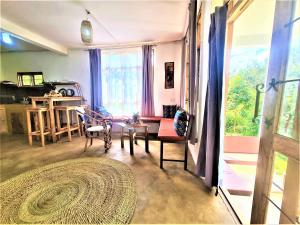 a living room with a table and chairs and a window at Holiday cottage by the river, Arusha in Arusha