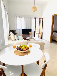 een woonkamer met een witte tafel en een fruitschaal bij Casa Chara in Symi