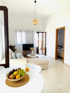 a living room with a bowl of fruit on a table at Casa Chara in Symi +26 photos