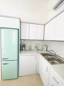 een keuken met een koelkast en een wastafel bij Casa Chara in Symi