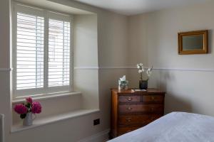 a bedroom with a bed and a dresser and a window at Number 40 in Kingsbridge
