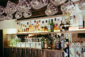 a bar with a lot of bottles and glasses at The Cotley Inn in Wambrook