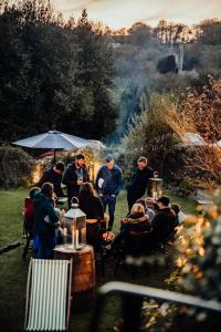 un grupo de personas sentadas en mesas en un jardín en The Cotley Inn en Wambrook