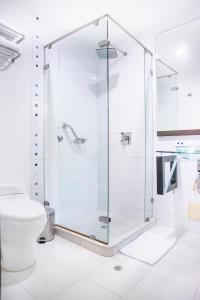 a glass shower in a bathroom with a toilet at Santorini Hotel Boutique in Santa Marta