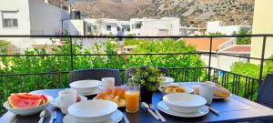 einen blauen Tisch mit Frühstücksspeisen auf dem Balkon in der Unterkunft Kelly's Urban Apartment in Elounda