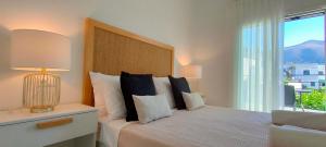 a bedroom with a large bed with a large window at Kelly's Urban Apartment in Elounda