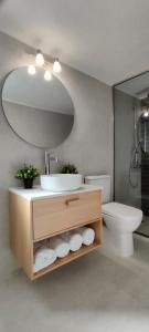 ein Badezimmer mit einem Waschbecken, einem WC und einem Spiegel in der Unterkunft Kelly's Urban Apartment in Elounda