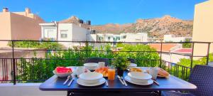 a blue table with plates of food on a balcony at Kelly's Urban Apartment in Elounda