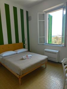 1 dormitorio con 1 cama con rayas verdes y blancas en Villa Mezzetti, en Petrignano sul Lago