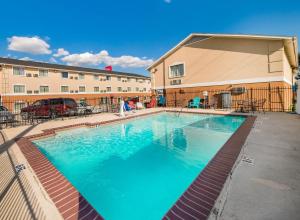 a large swimming pool in front of a building at Red Roof Inn & Suites Denton in Denton