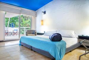 a bedroom with a bed with a backpack on it at Hotel Santorini Express y Cabañas in Santa Marta