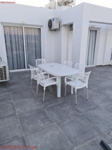a white table and chairs on a patio at Latchi Area Apartments in Lachi