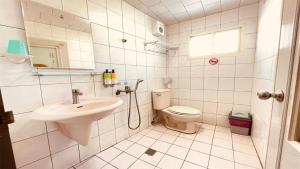 La salle de bains blanche est pourvue d'un lavabo et de toilettes. dans l'établissement DaFeng Homestay, à Île Lamay